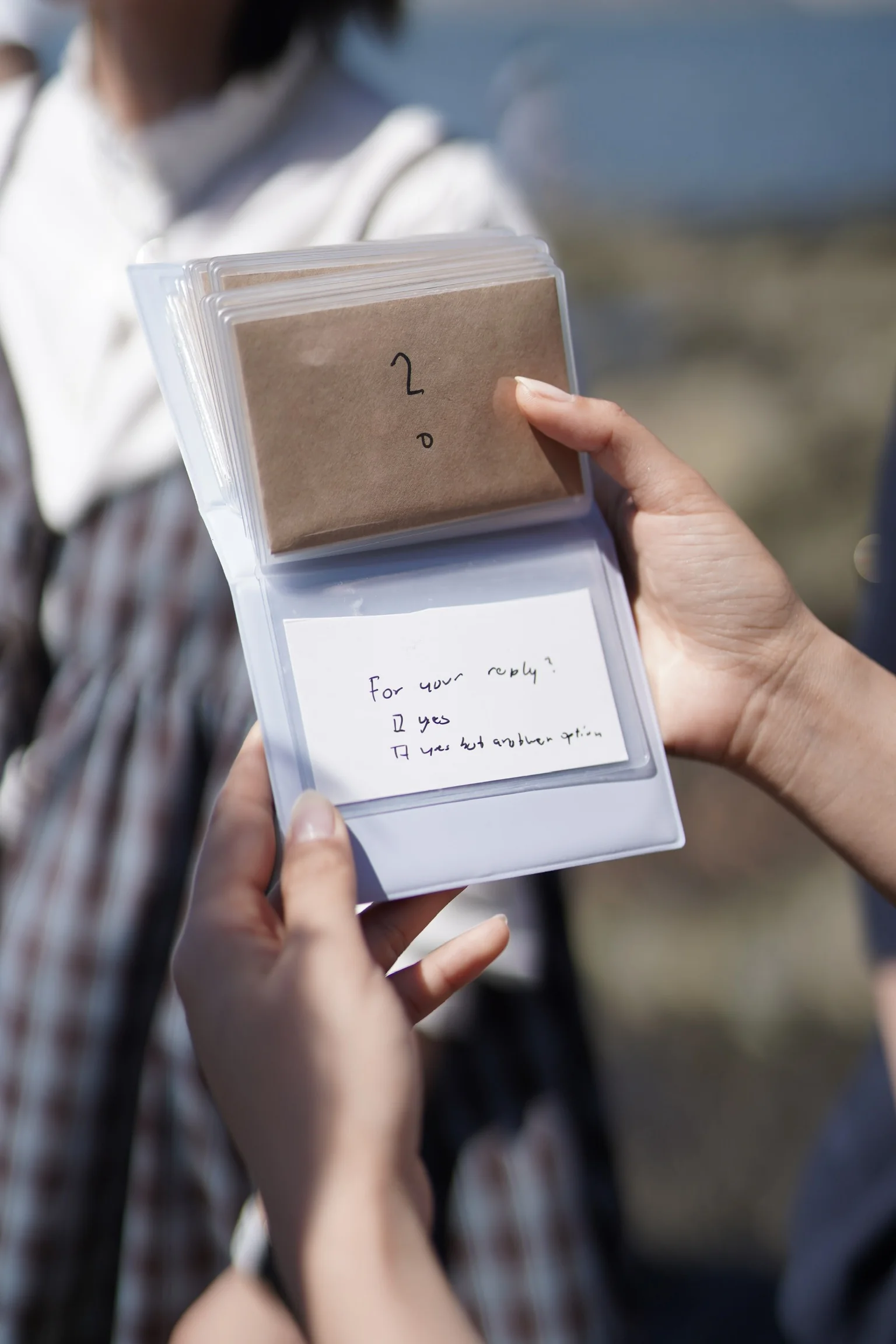 A hand holding the little book used for the proposal